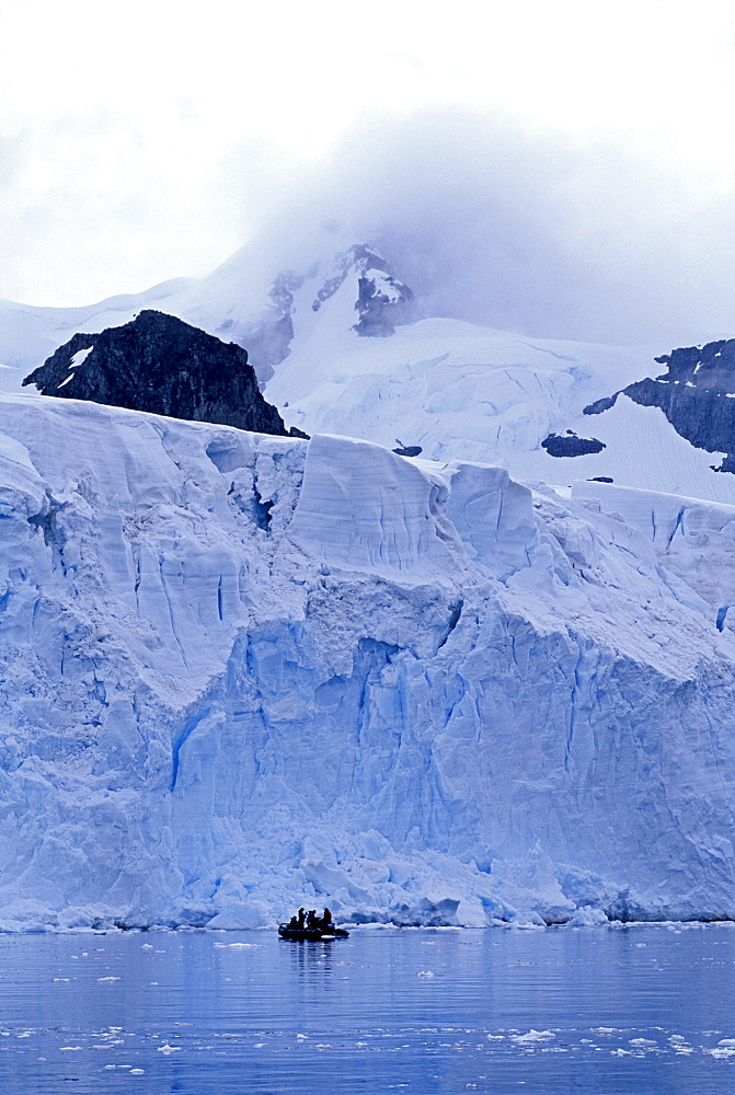 Tourists in zodiac below edge of glacier, Antarctica, Polar Regions