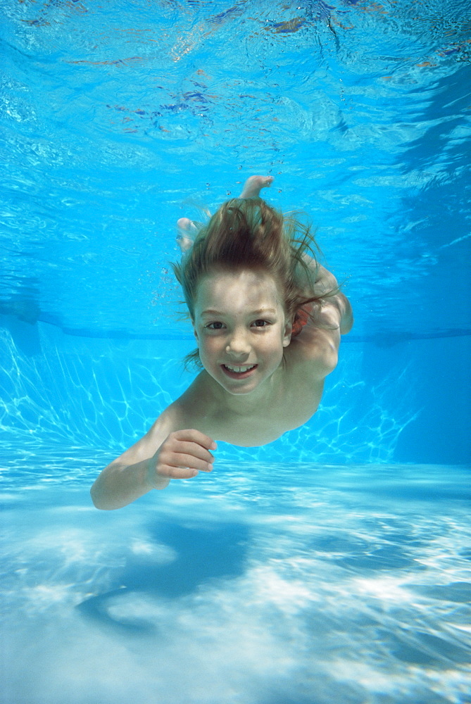 Young boy swimming underwater