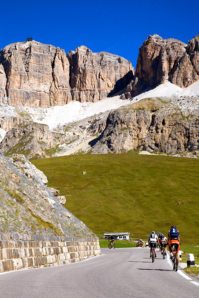 Cyclist during Pordoi pass with view on Sella mountain and  Piz Bovû, Dolomites, Fassa valley, Trentino Alto Adige, Italy, Europe