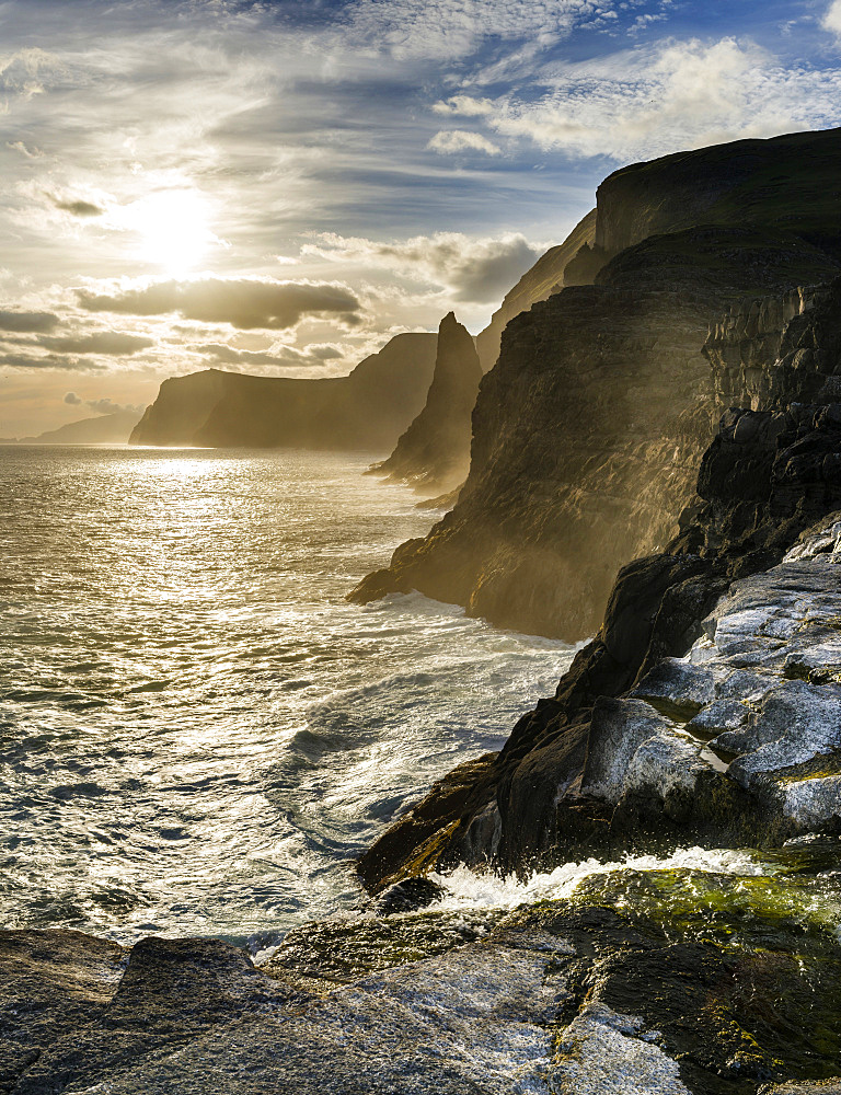 The west coast near Traelanipa with waterfall Bosdalafossur at sunset.  The island Vagar, part of the Faroe Islands in the North Atlantic.  Europe, Northern Europe, Denmark, Faroe Islands