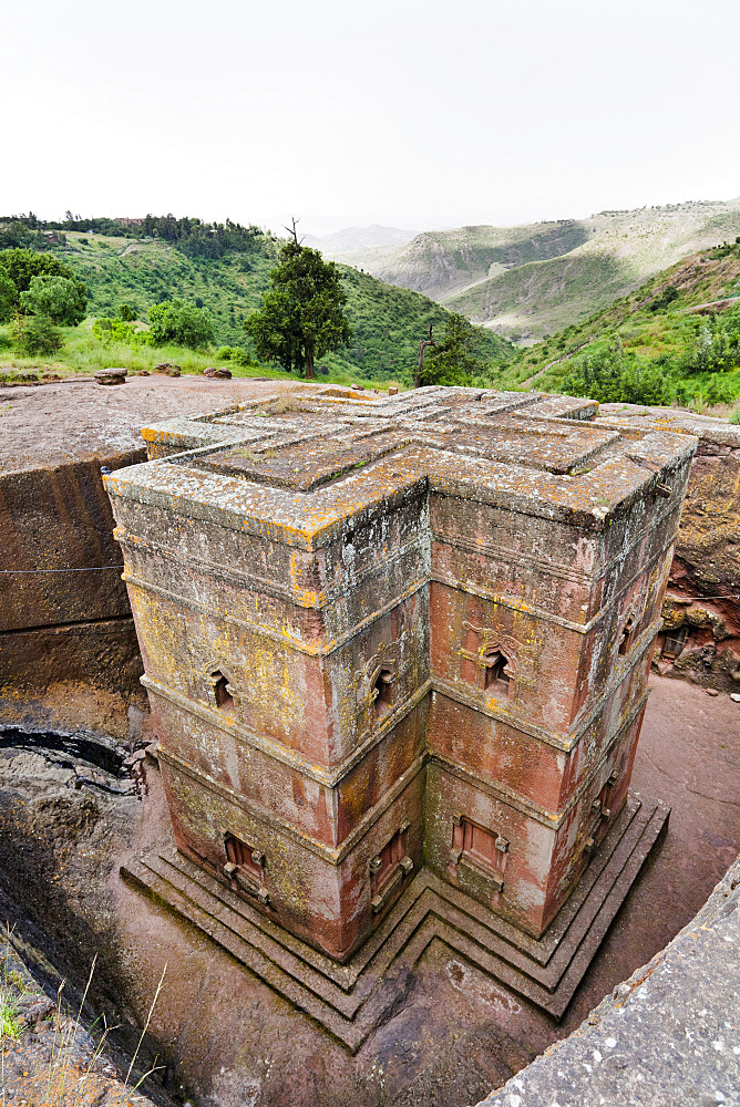 The rock-hewn churches of Lalibela in Ethiopia. Pilgrim praying in front of a church.  The churches of Lalibela have been constructed in the 12th or 13th century. They have been hewn from the solid rock and are considered to be one of the largest monolithic structures ever build by mankind, Africa, East Africa, Ethiopia, Lalibela