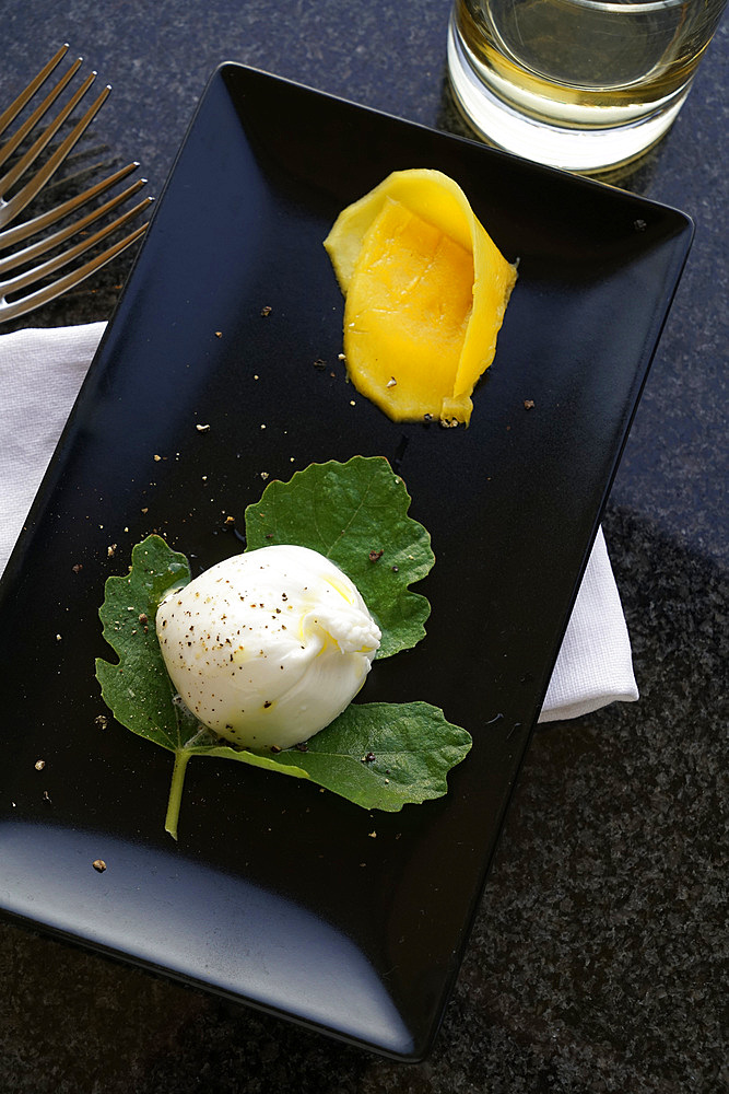 Burratina cheese and mango slice appetizer