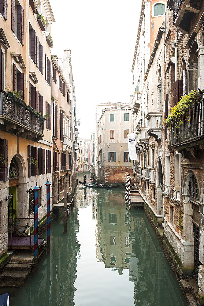 A view over the canal in winter time, in the distance you can see a gondola, a typical boat used in Venice to wade channels led by a sailor, Veneto, Italy, Europe