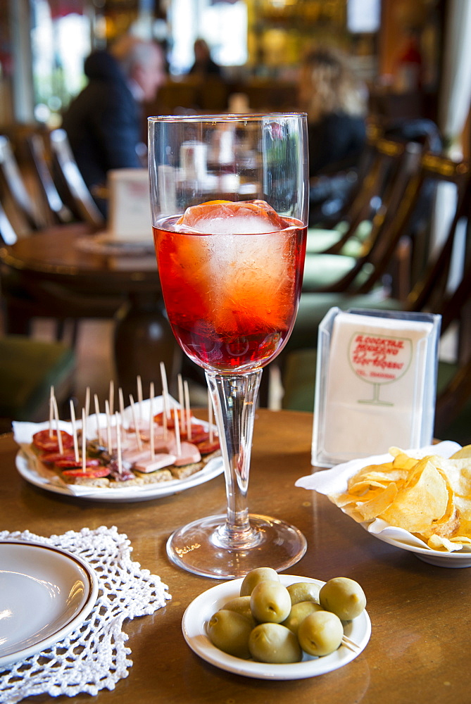 Still life of Negroni Sbagliato with olives, chips and some appetizer. Negroni Sbagliato is one of the most important cocktail invented at Bar Basso, Milano, Lombardy, Italy, Europe