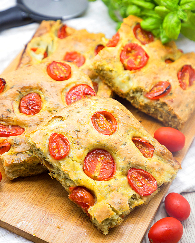 Wholemeal flour focaccia flat bread, cherry tomatoes and basil, Italy, Europe