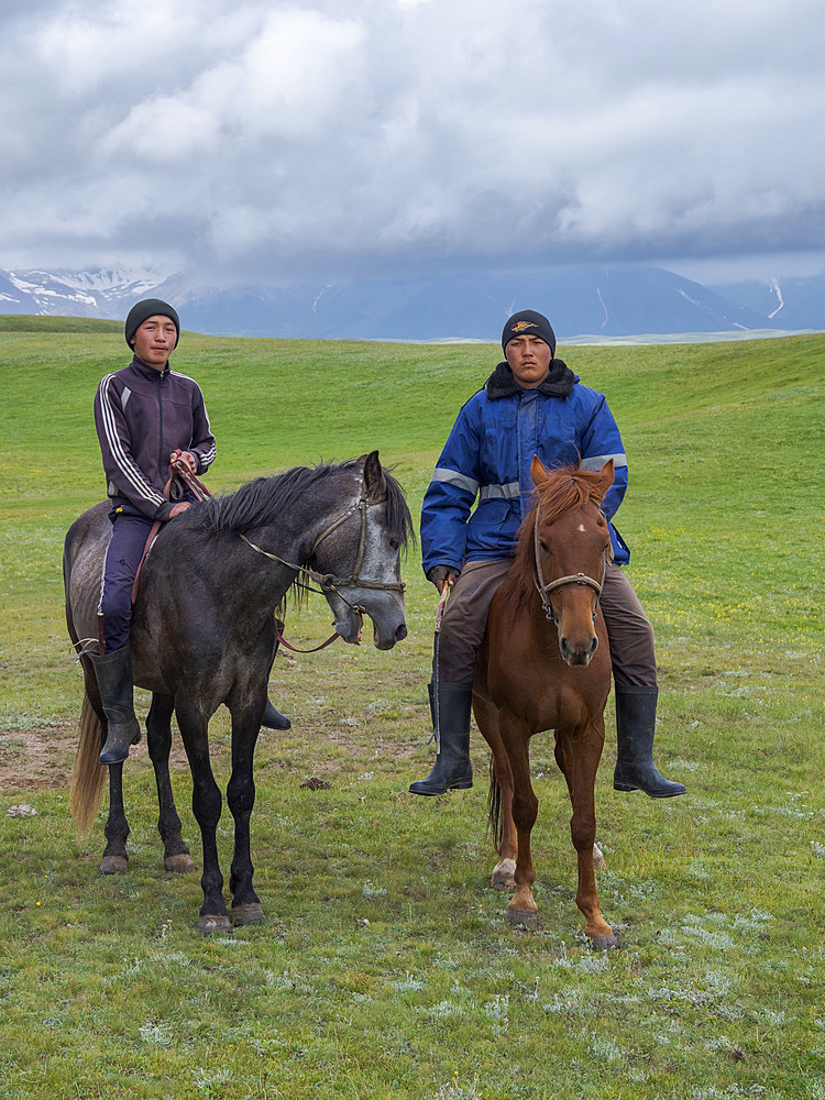 Young shepherds on their summer pasture. Alaj Valley in front of the Trans-Alay mountain range in the Pamir mountains. Asia, central Asia, Kyrgyzstan