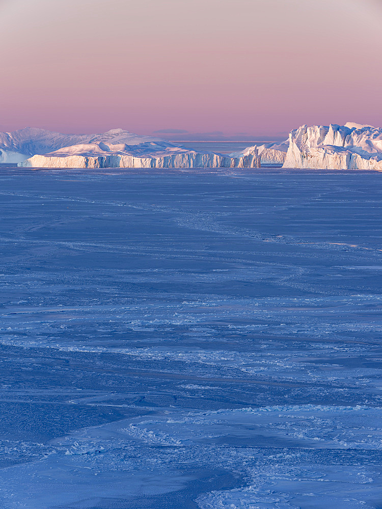 Sunrise during winter at the Ilulissat Icefjord, located in the Disko Bay in West Greenland, the Icefjord is part of the UNESCO world heritage. America, North America, Greenland, Denmark