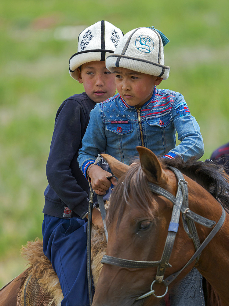 Child on horseback. Folk Festival commemorating the origin myth the Tien Shan Maral (Tian Shan wapiti), an origin myth of the Kyrgyz tribes. Near Tasch Baschat, Naryn region. Asia, Central Aisa, Kyrgyzstan