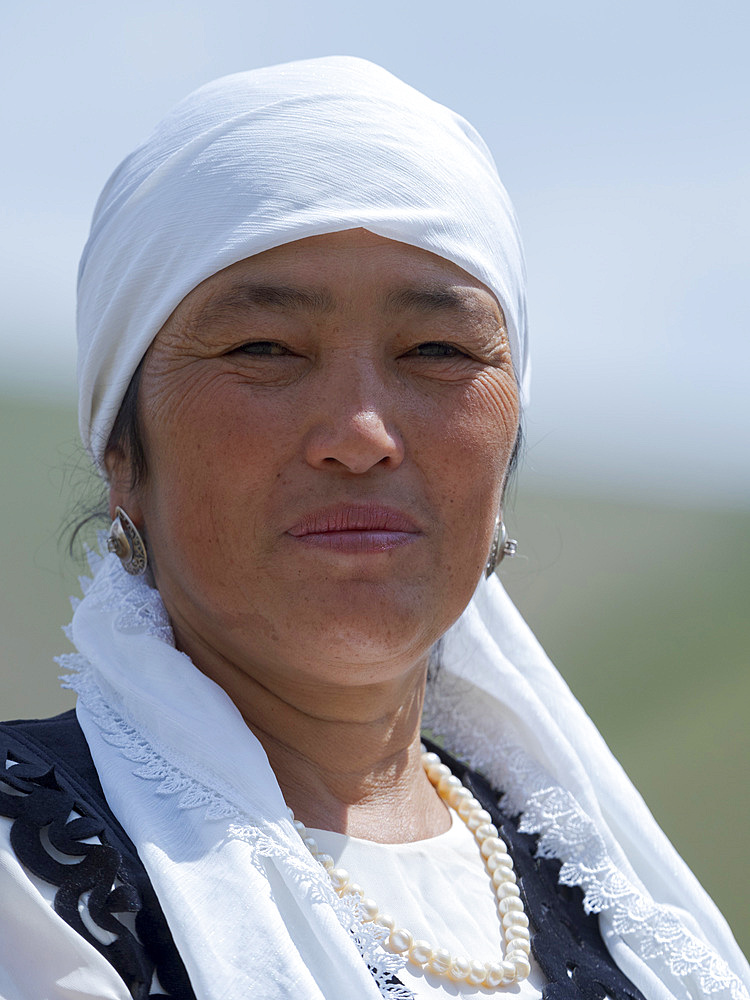 Woman in traditional garb having fun on a swing. Folk Festival commemorating the origin myth the Tien Shan Maral (Tian Shan wapiti), an origin myth of the Kyrgyz tribes. Near Tasch Baschat, Naryn region. Asia, Central Aisa, Kyrgyzstan