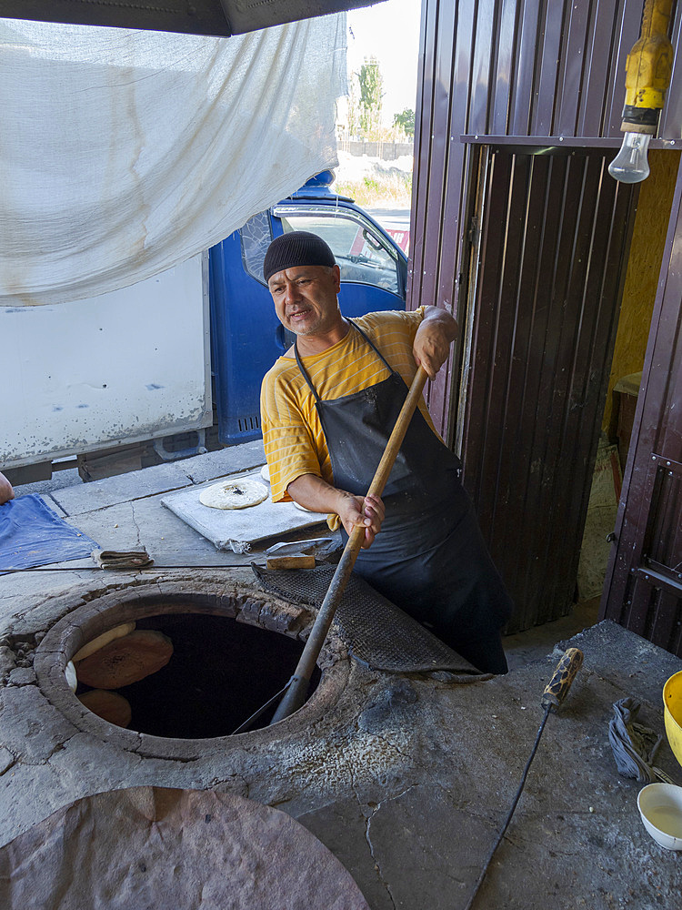 Typical, Traditional bakery making Lepjoschka bread in a clay oven. City Jalal-Abad (Dzhalal-Abad, Djalal-Abat, Jalalabat) in the Fergana Valley close to the border to Uzbekistan. Asia, central Asia, Kyrgyzstan