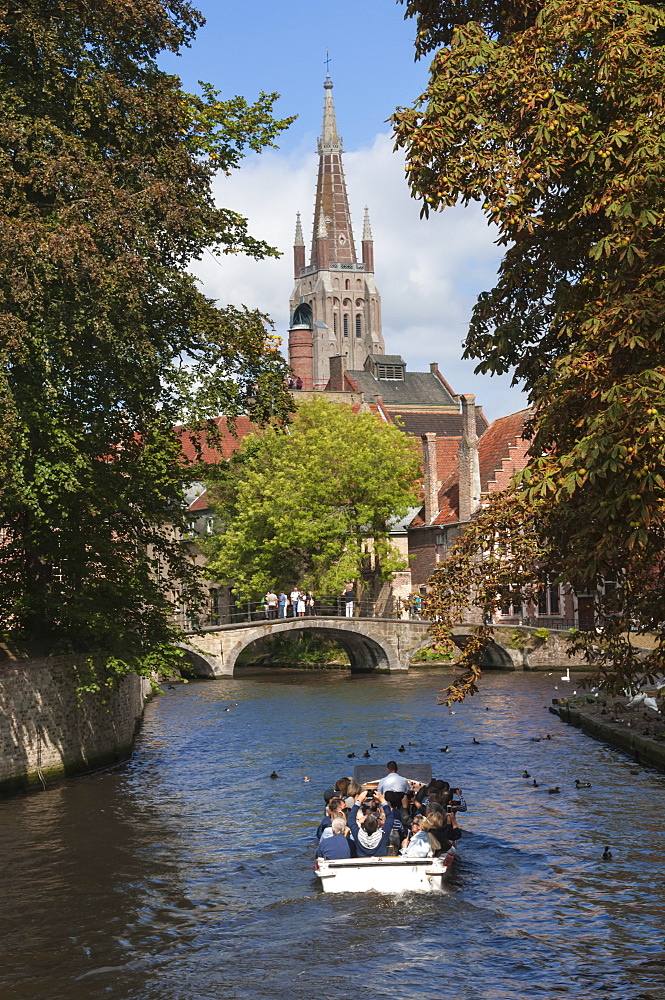 Bridge to Begijnhof, and spire of Church of Our Lady, tourist launch, Bruges, UNESCO World Heritage Site, Belgium, Europe