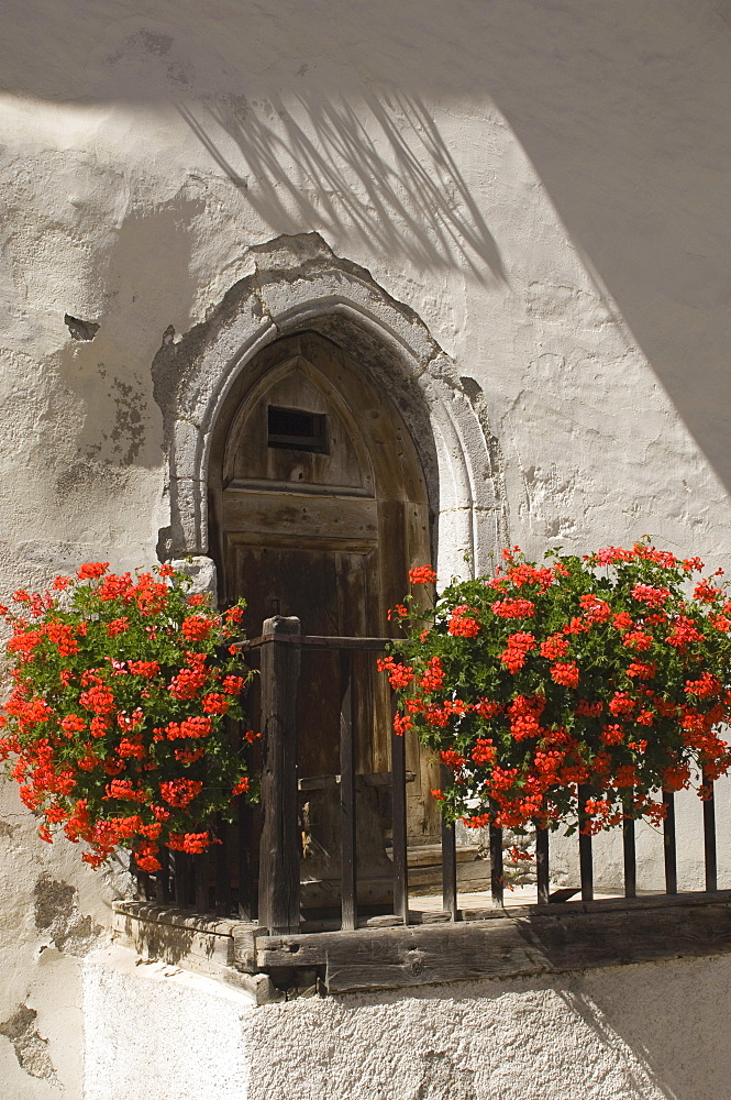 Doorway with trailing geraniums, Abbey di Monte Maria, near Burgusio, Reschen Pass, Western Dolomites, Italy, Europe