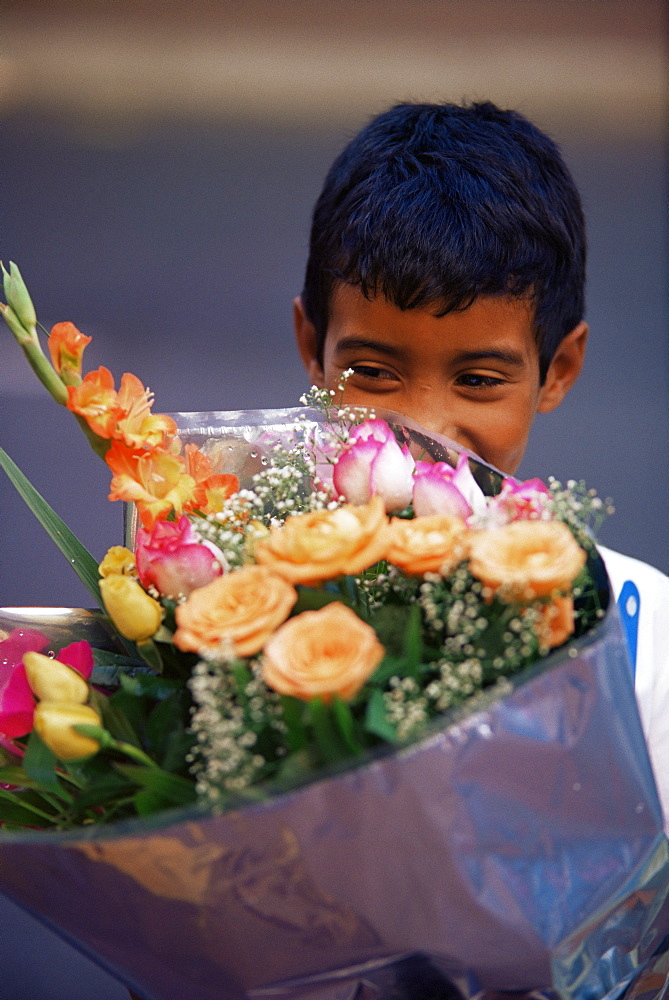 Young boy holding flowers at the flower market on Adderley Street, Cape Town, South Africa, Africa