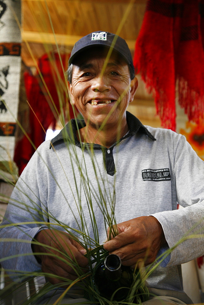 Portrait of a Quechua man weaving with palm leaves in the Cafayate market, Salta Province, Argentina, South America