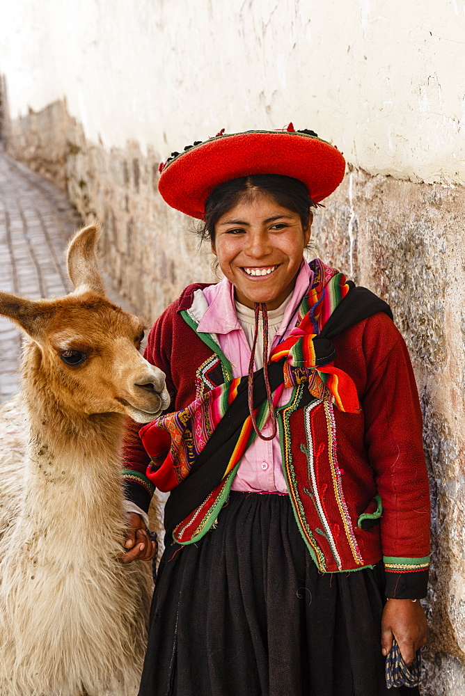 Portrait of a Quechua girl in traditional dress with a llama, Cuzco, Peru, South America