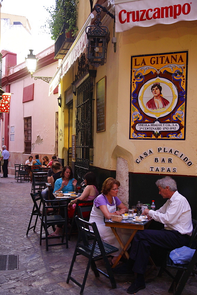 People sitting at a tapas bar in Barrio Santa Cruz, Seville, Andalucia, Spain, Europe