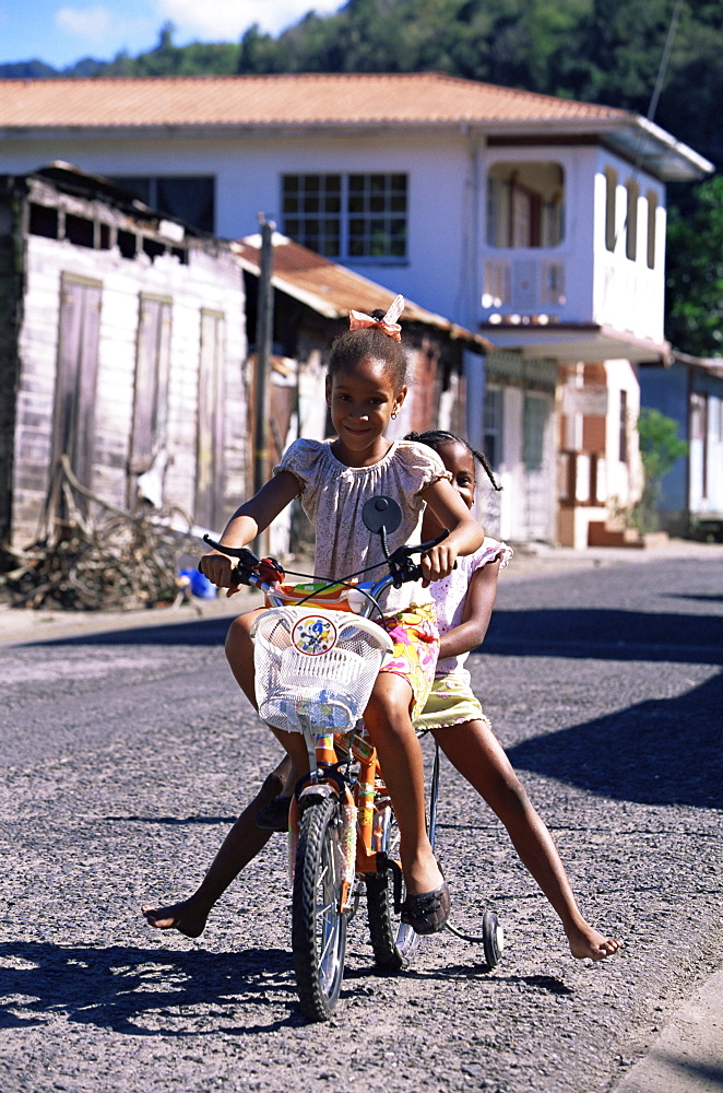 Young girls riding a bicycle at Anse La Raye, St. Lucia, Windward Islands, West Indies, Caribbean, Central America