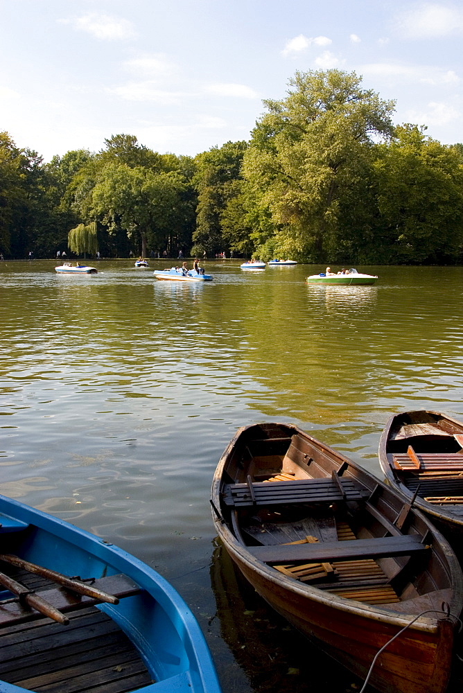 People cruising in a boat on the Kleinhesselohe lake at the Englischer Garten, Munich, Bavaria, Germany, Europe