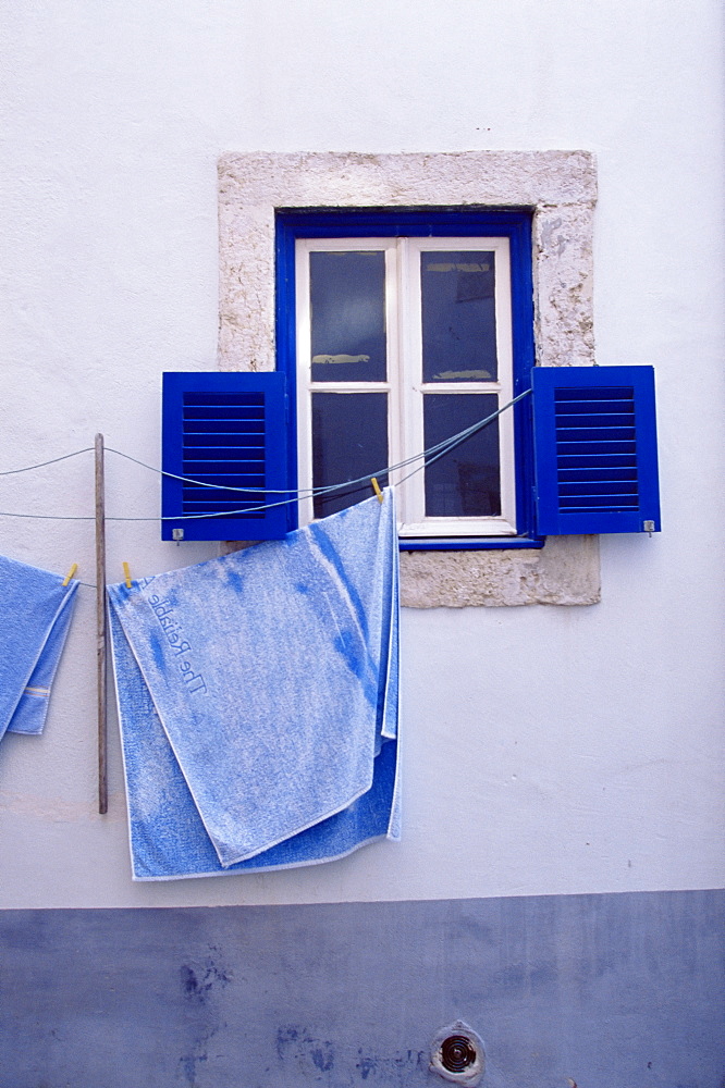 Laundry hanging on line at window in the Moorish quarter of Alfama, Lisbon, Portugal, Europe