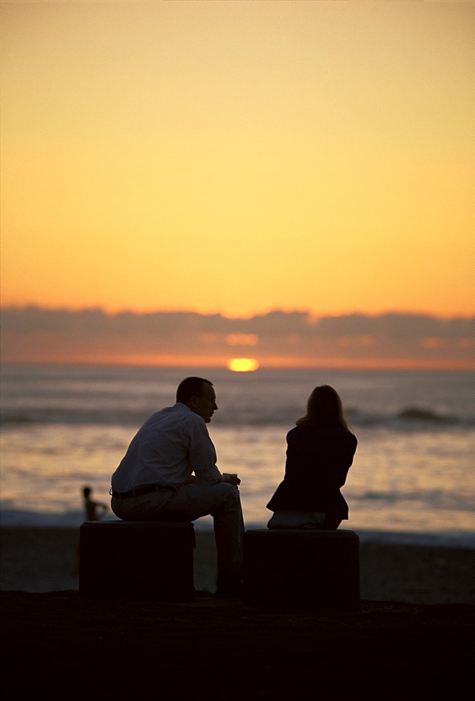 Silhouette of a couple watching the sunset, Camps Bay beach, Cape Town, South Africa, Africa