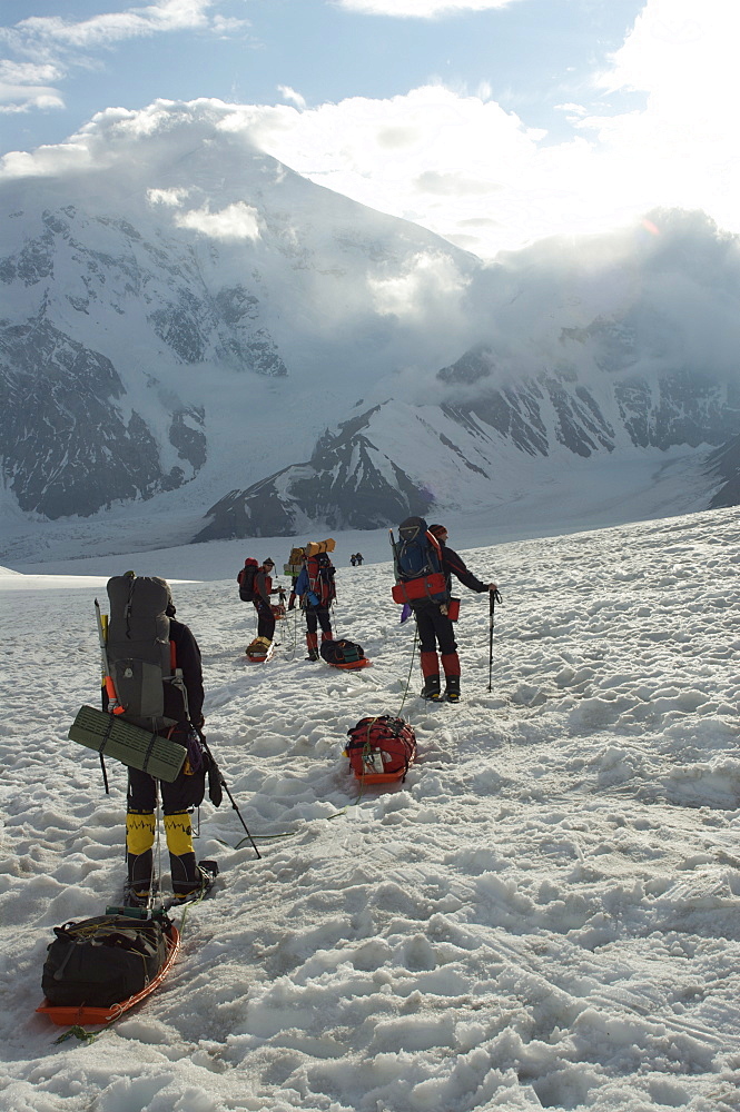 Hikers break with Mount Foraker on the left and Mount Crosson on the right, in distance, Denali National Park, Alaska, United States of America, North America