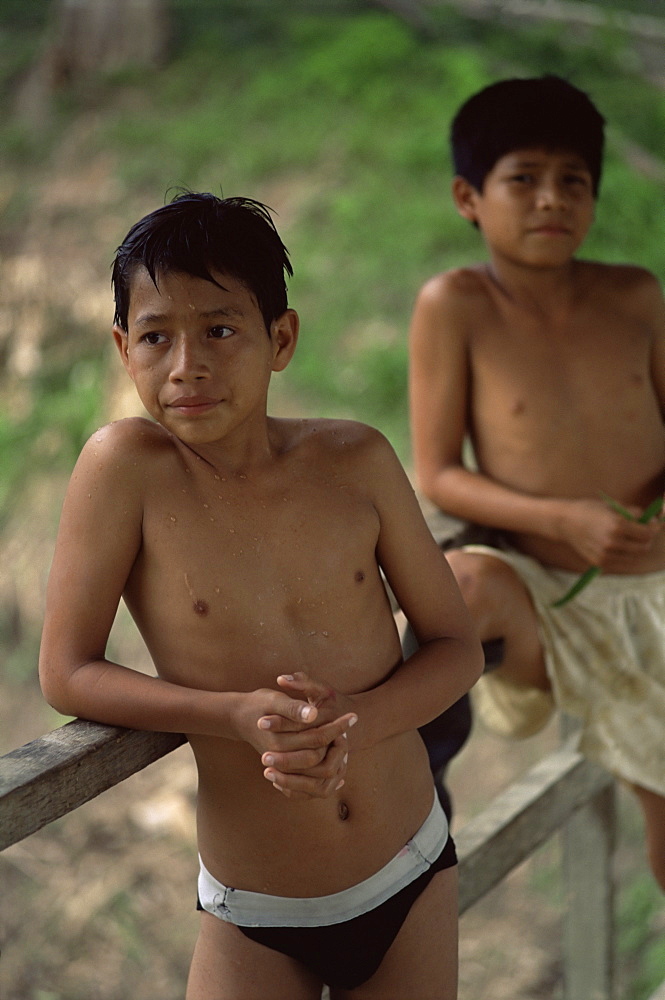 Local boys hang out on bridge after jumping off it, Amazon River, Peru, South America