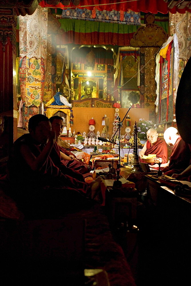 Shaft of light falls on Tibetan Buddhist monks, Meru Nyingba monastery, Bharkor, Lhasa, Tibet, China, Asia