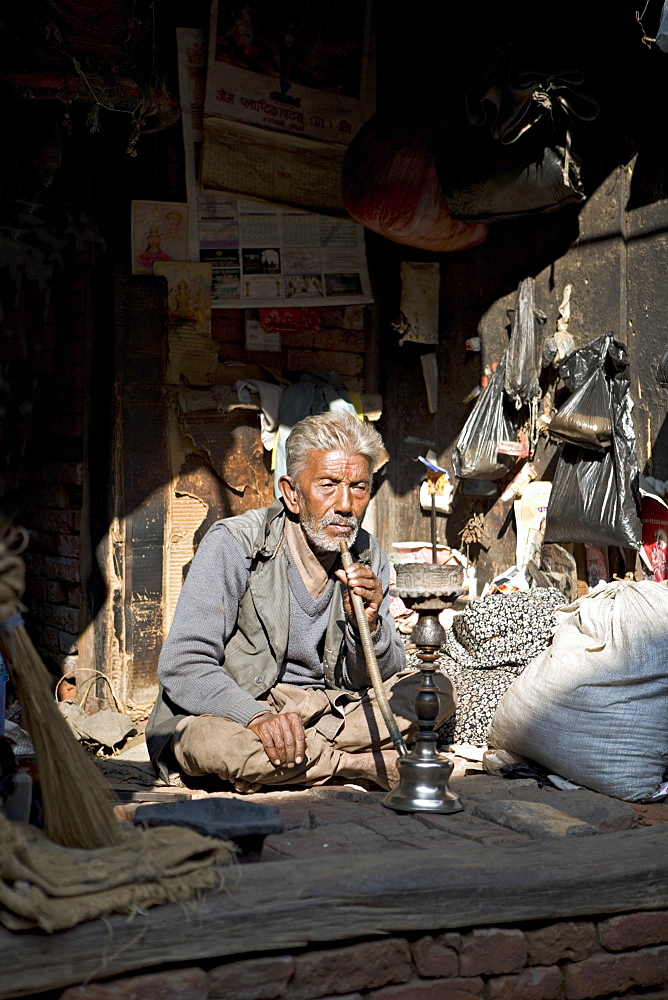 Old man with pipe, Bhaktapur, Kathmandu valley, Nepal, Asia