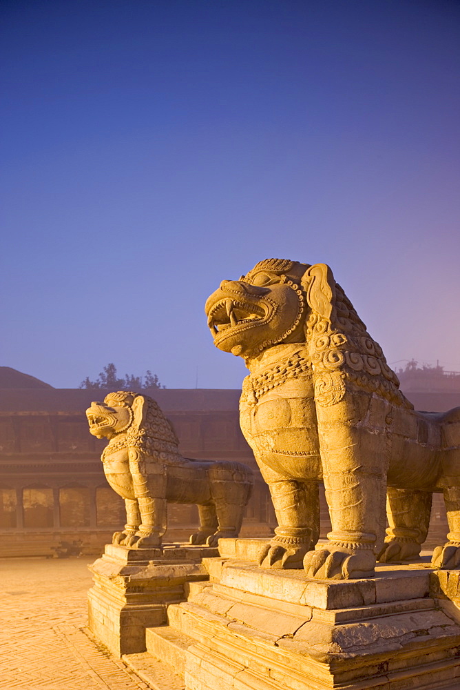 Stone lions, Durbar Square, Bhaktapur, Kathmandu valley, Nepal. Foggy winter dawn, november 2005.