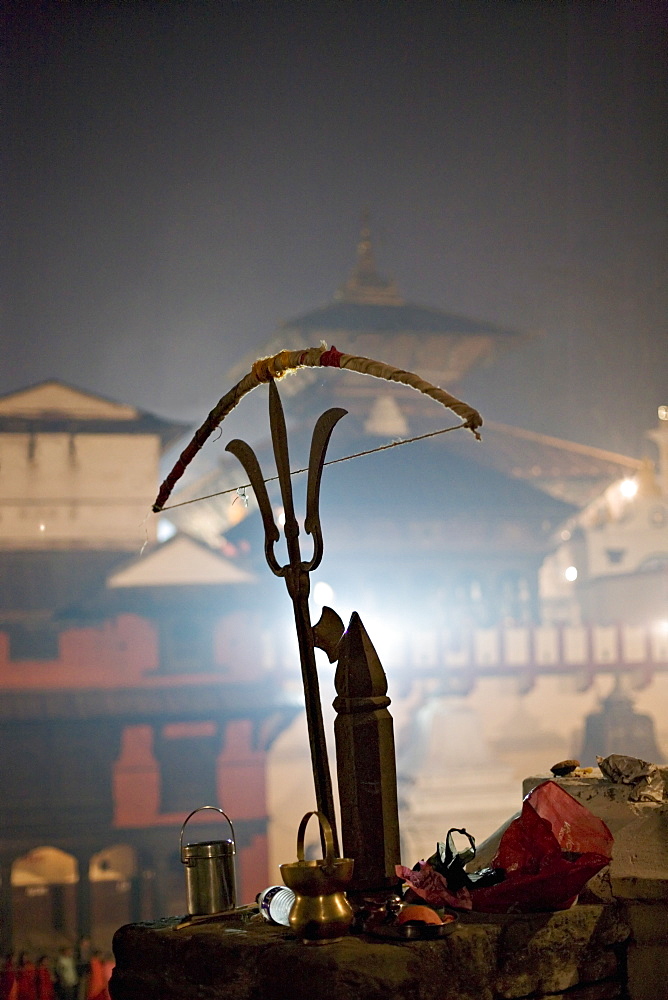 A holy man's bow placed on a bronze sculpture of a Shiva trident, Hindu festival of Shivaratri, Pashupatinath, Kathmandu, Nepal, Asia