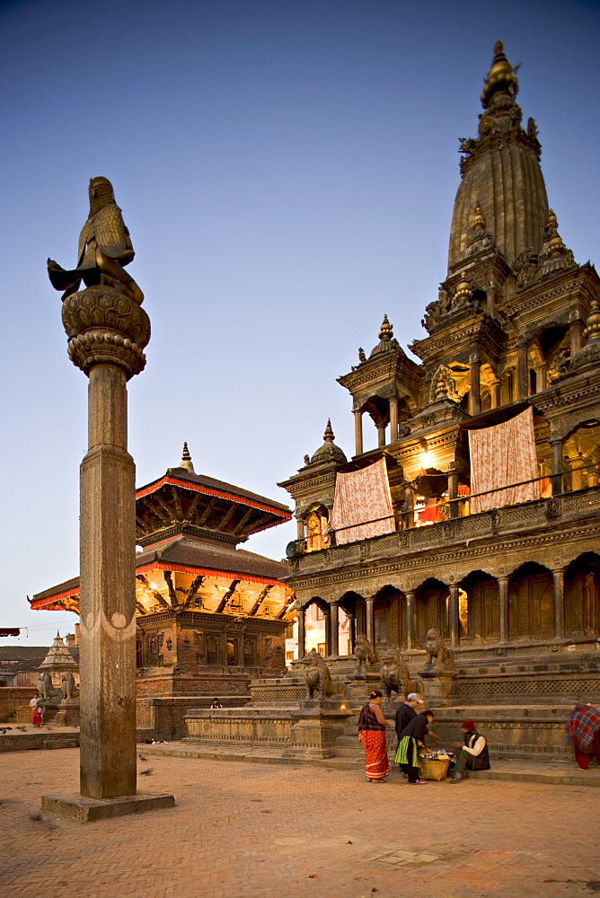 Durbar Square at dawn with Garuda statue on column facing Krishna Mandir temple built in 1637 in Indian style, with twin roofed pagoda style Jagannarayan temple behind, Patan, Kathmandu Valley, UNESCO World Heritage Site, Nepal, Asia