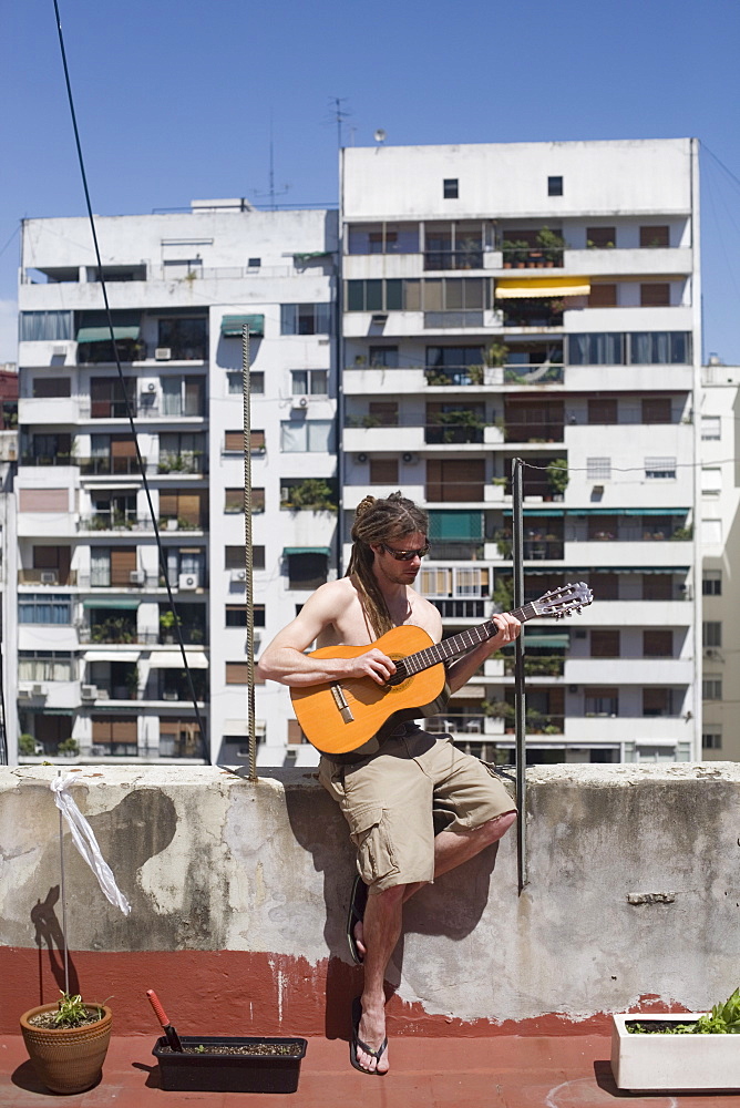 Man playing guitar on rooftop, Buenos Aires, Argentina, South America