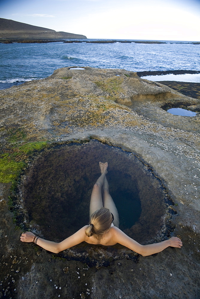 Young woman relaxing in natural pool, Santa Cruz, Argentina, South America