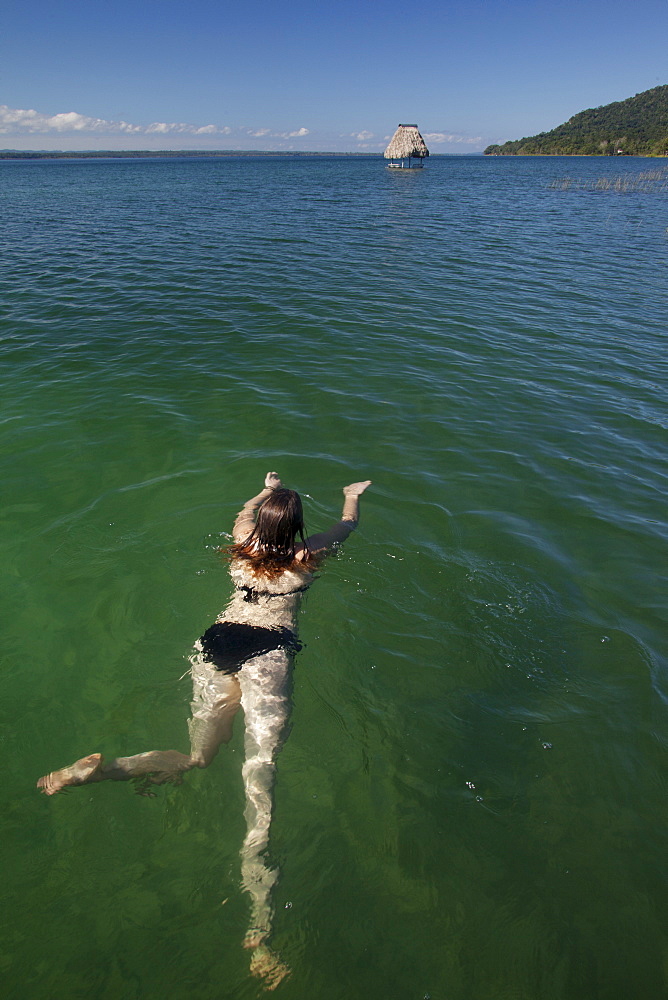 Woman swimming in Lago Peten Itza, Guatemala, Central America