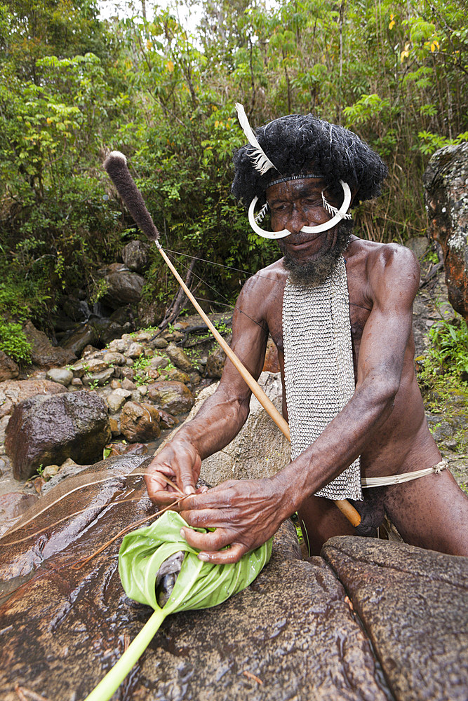 Dani chief showing traditional salt extraction at Jiwika Salt Spring, Baliem Valley, West Papua, Indonesia, Southeast Asia, Asia