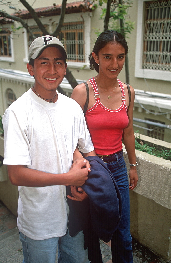 Cuenca World Heritage City & Ecuador's third largest city, famous for its colonial architecture student couple walking together on street, Highlands, Ecuador