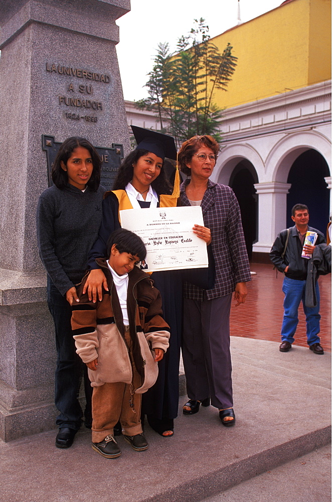 Students at the National University of Trujillo being photographed with Bachelor of Education Degrees after graduation ceremony, Trujillo, Peru