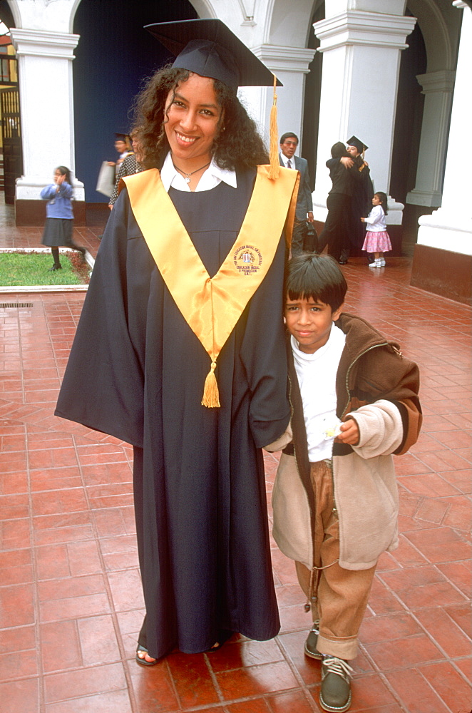 Students at the National University of Trujillo being photographed with Bachelor of Education Degrees after graduation ceremony, Trujillo, Peru