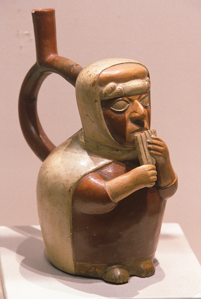 Mochica (Moche) Culture, 200BC-800AD, north coast ceramic 'stirrup-spout' vessel with a musician blowing a panpipe, Peru