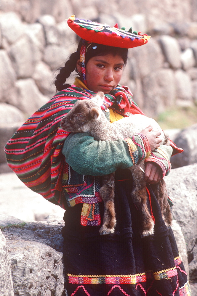 A young Quechua girl and her lamb at Tambo Machay, the ancient Incan Royal Baths near Cuzco, Peru