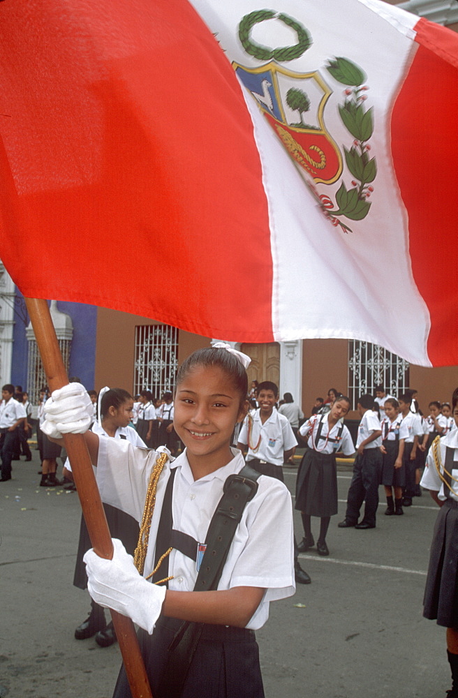 A colonial city on Peru's north coast the Tribute to the Flag Parade on Plaza de Armas portrait of school girl holding a flag, Trujillo, Peru