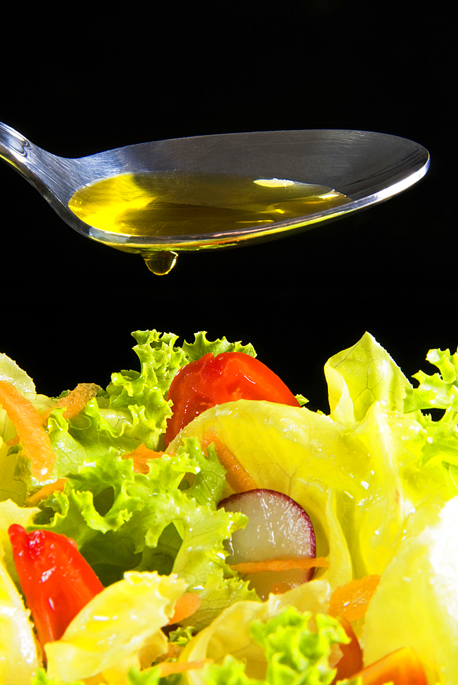 Olive oil in a spoon and mixed salad, Tuscany, Italy, Europe