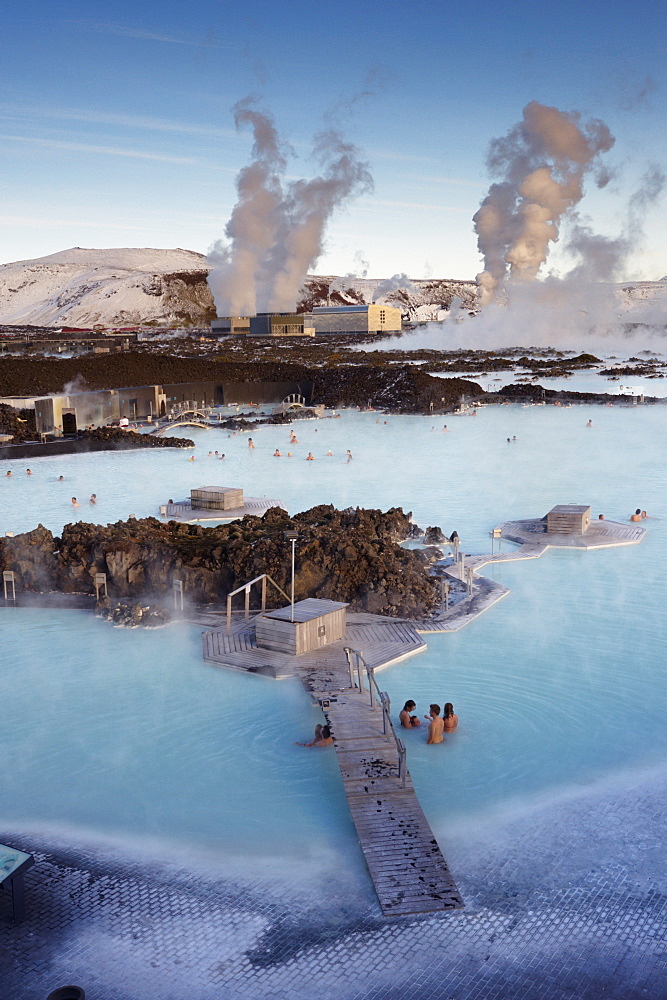 People relaxing in Blue Lagoon geothermal spa, Svartsengi Geothermal Power Station in the distance, Grindavik, Reykjanes Peninsula, Iceland, Polar Regions