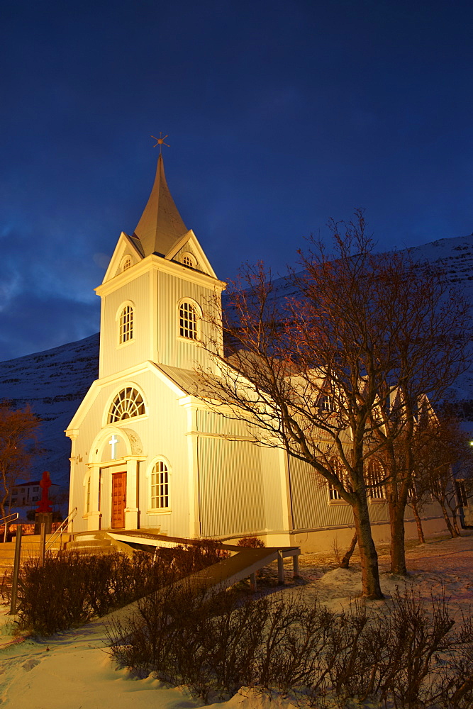 Traditional wooden church at night, built in 1922, at Seydisfjordur, a town founded in 1895 by a Norwegian fishing company, now main ferry port to and from Europe in the East Fjords, Iceland, Polar Regions