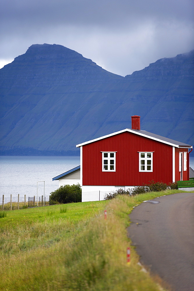 Houses at Hellur, small village near Oyndarfjordur, cliffs of Kalsoy Island in background, Eysturoy, Faroe Islands (Faroes), Denmark, Europe