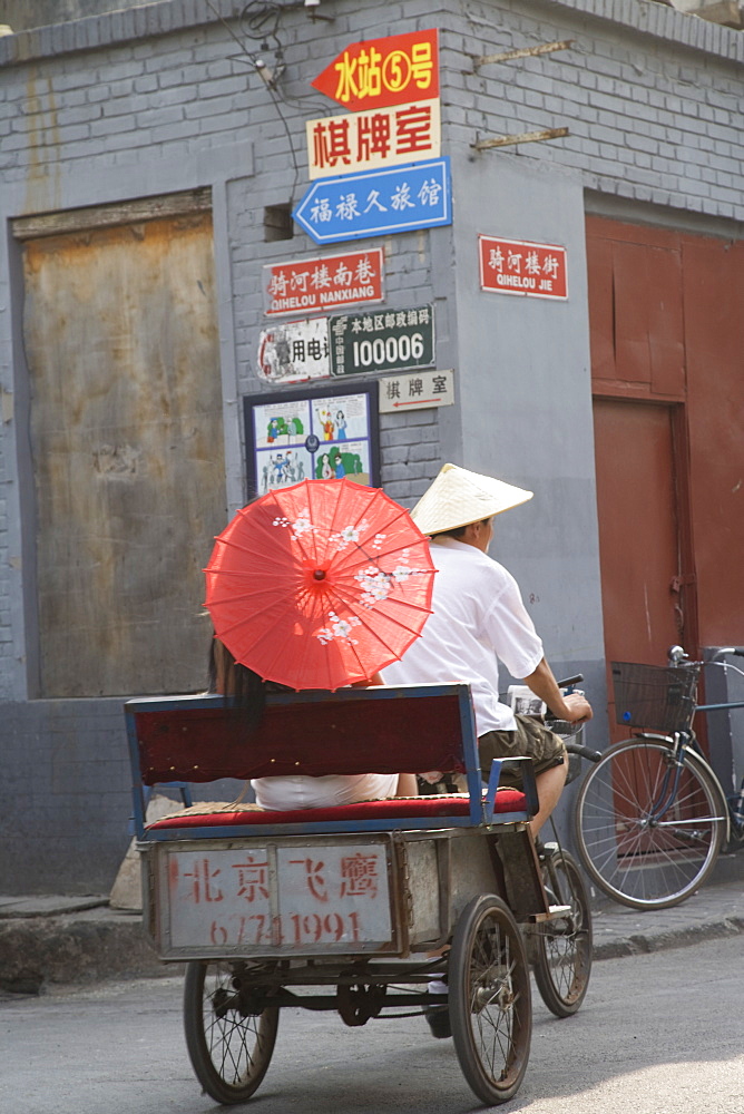 Asian woman riding in cycle rickshaw, Hutong District, Beijing, China, Asia