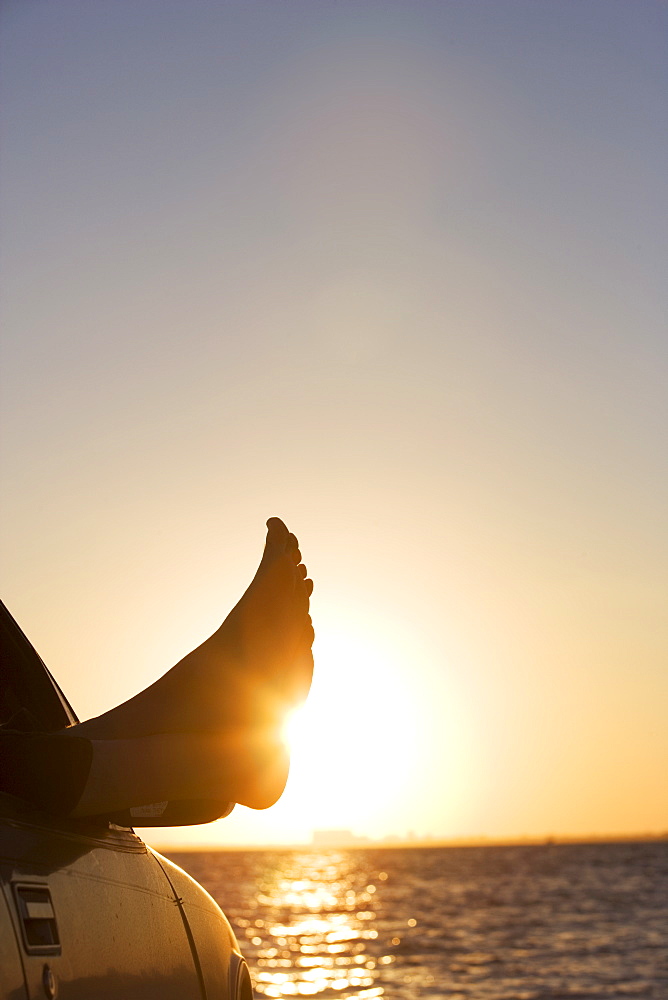 Man's feet in car at sunset in Key Byscaine, Miami, Florida, United States of America, North America