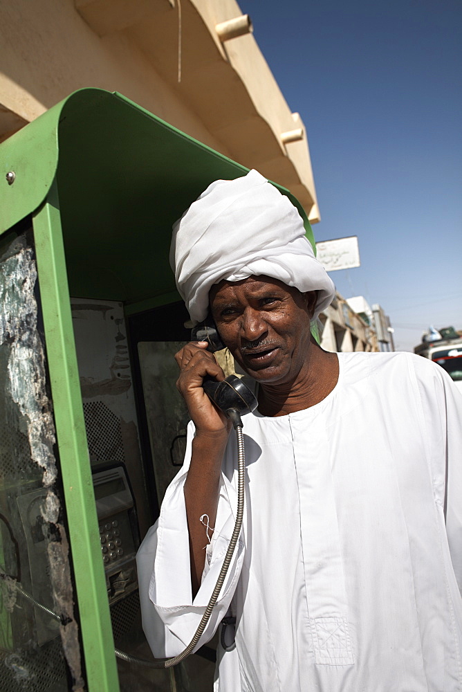 Sudanese man using a telephone in the town of Karima, Sudan, Africa