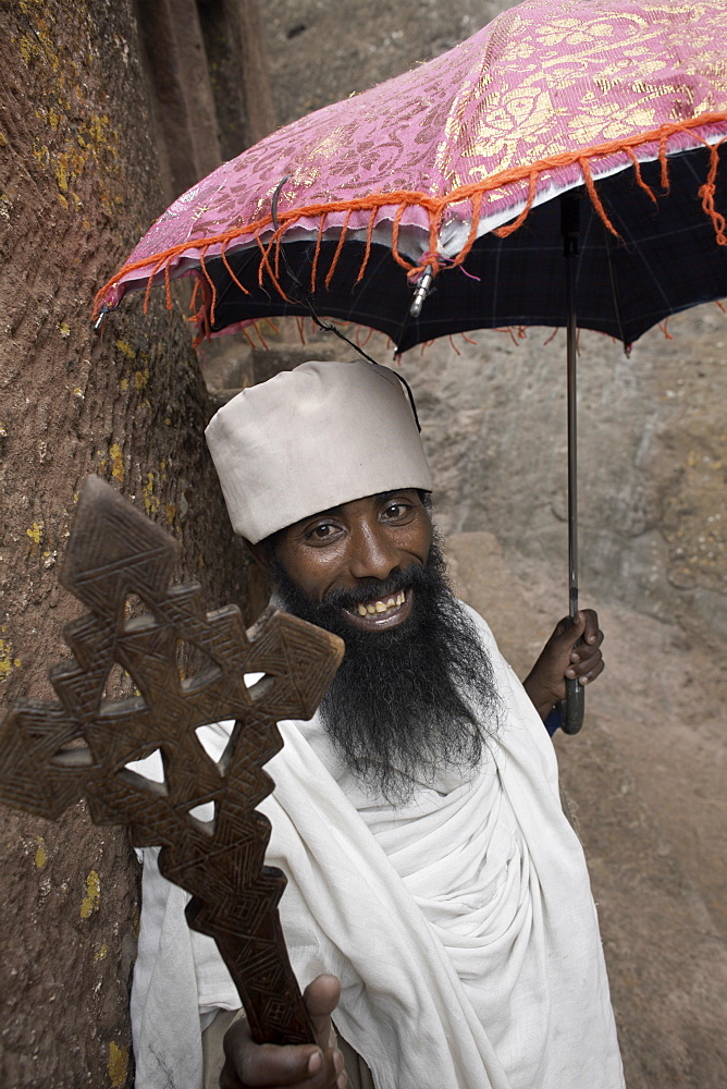 A priest holds a cross at the rock-hewn church of Bet Giyorgis (St. George), in Lalibela, Ethiopia, Africa