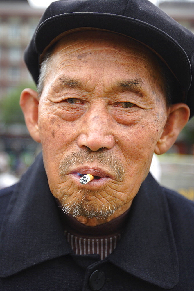 Elderly man smoking cigarette, Xi'an, China, Asia